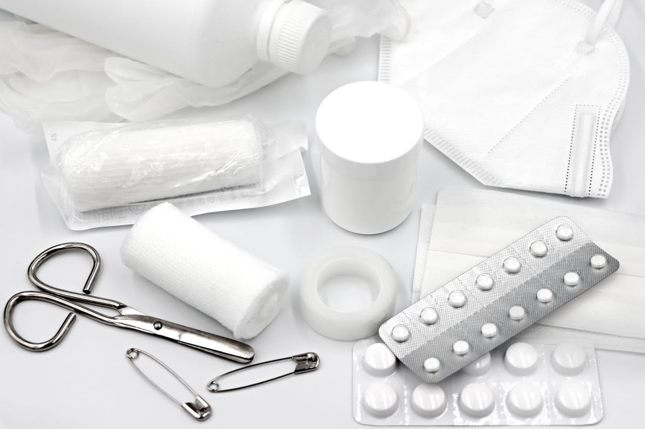 Services A flat lay of essential first aid supplies and medical equipment on a white background.